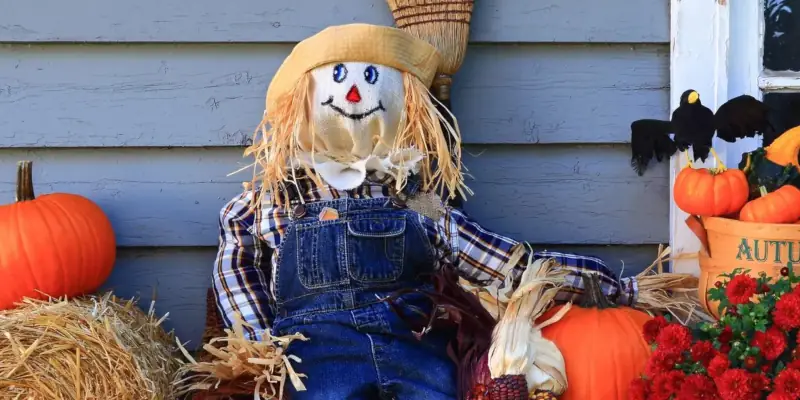 Autumn scarecrow with pumpkins and flowers on display.