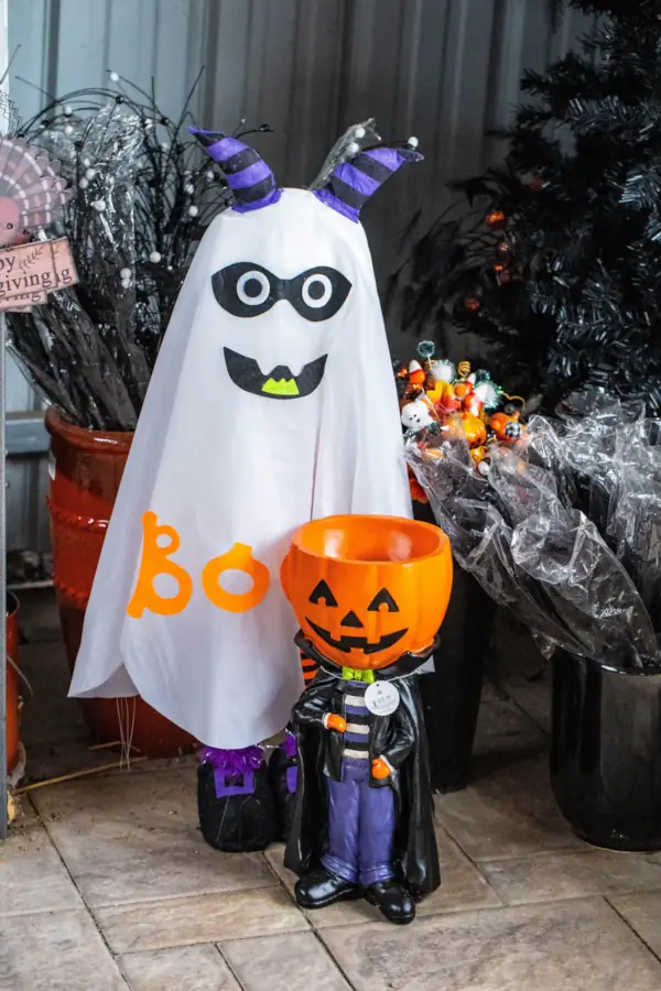 Halloween decorations featuring a ghost with "Boo" and a jack-o’-lantern figure in a cape, surrounded by festive, colorful ornaments.