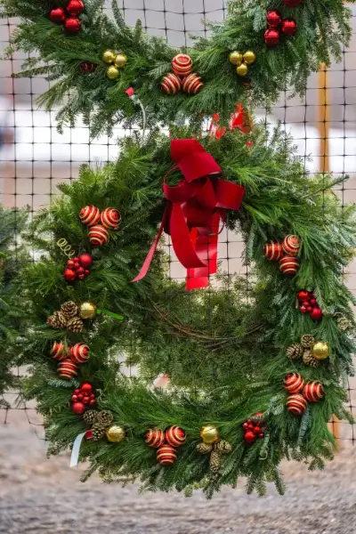 Festive Christmas wreath with red and gold ornaments.