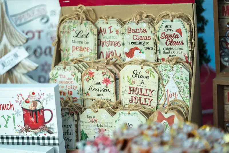 Assorted Christmas-themed decorative signs displayed for sale.